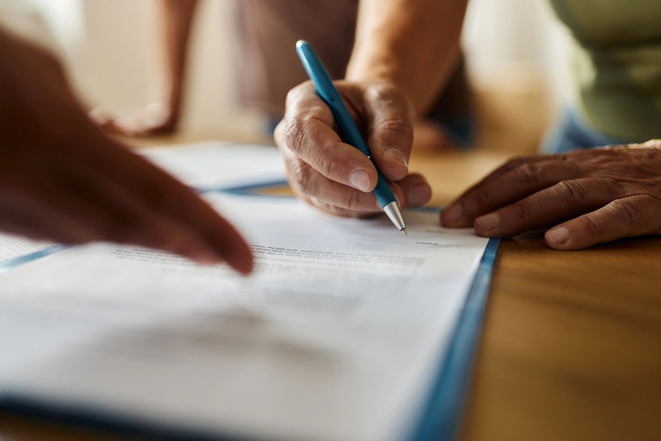 Hands signing paperwork representing grant applications
