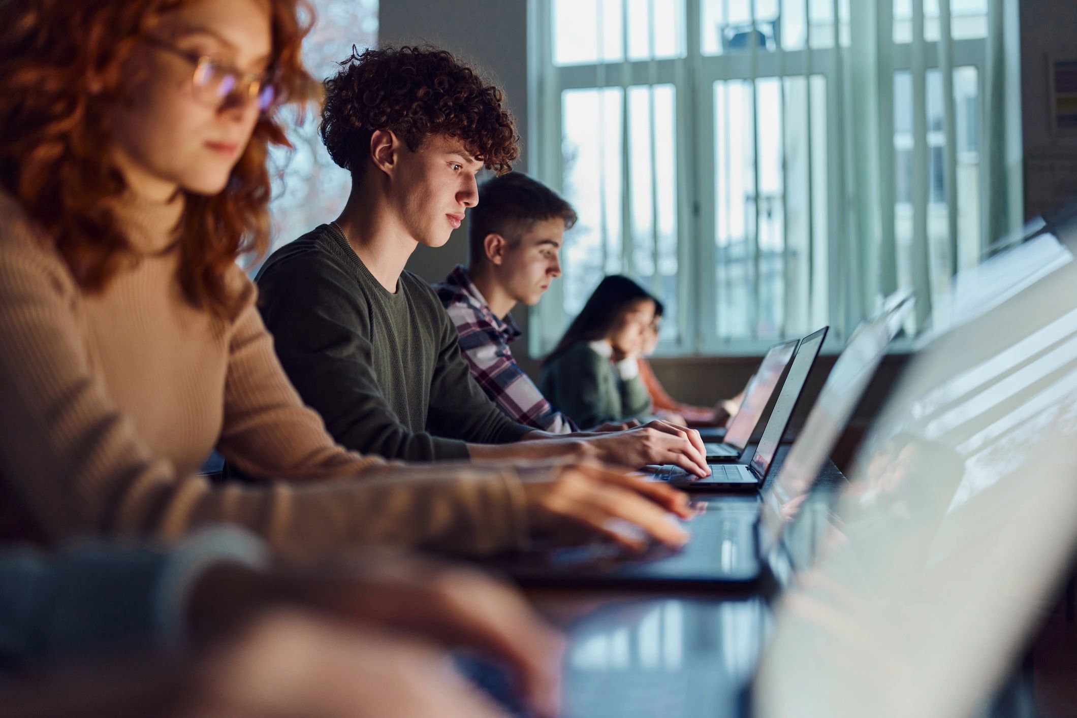 Students coding on laptops in a classroom