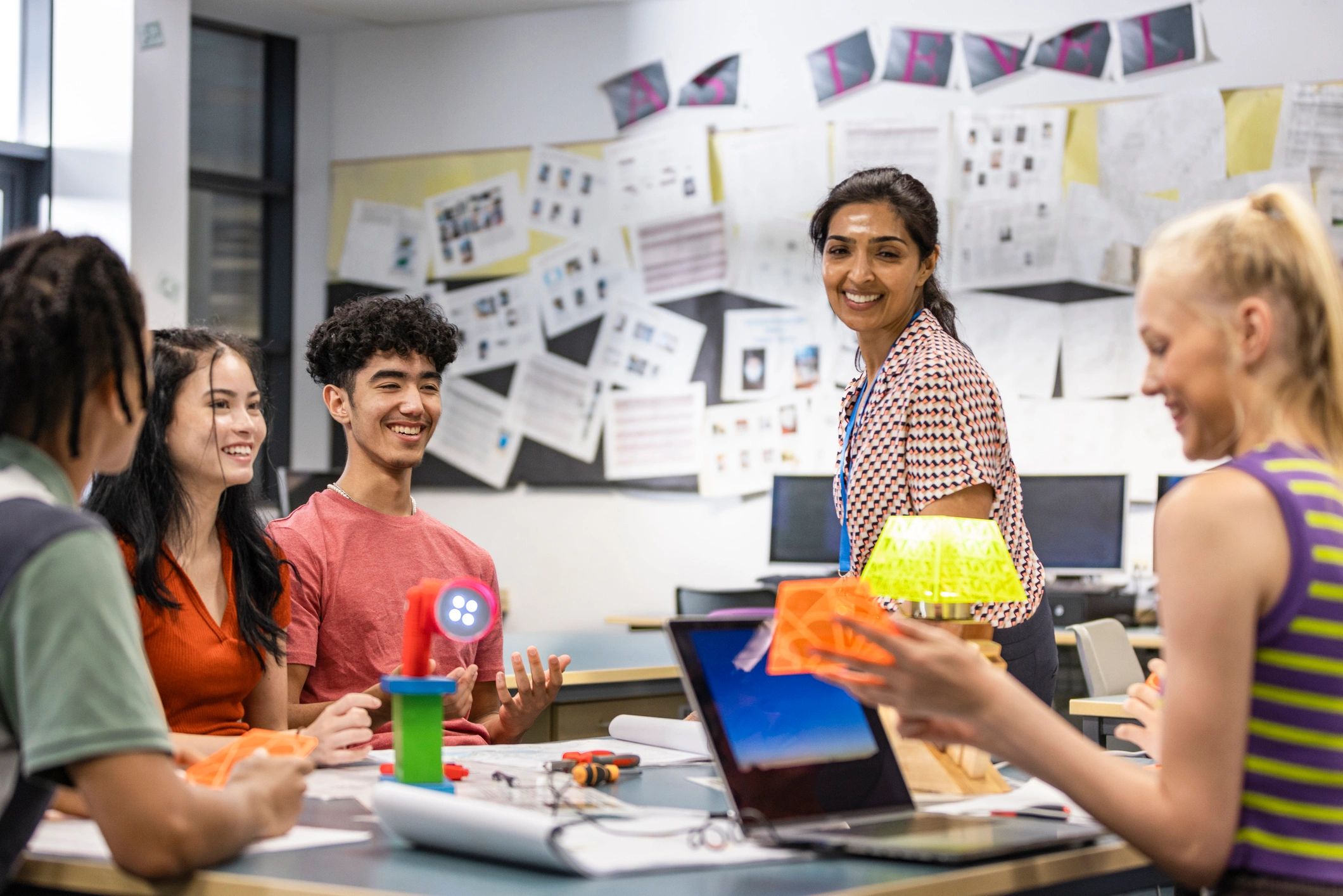 Educator and students discussing work in a classroom