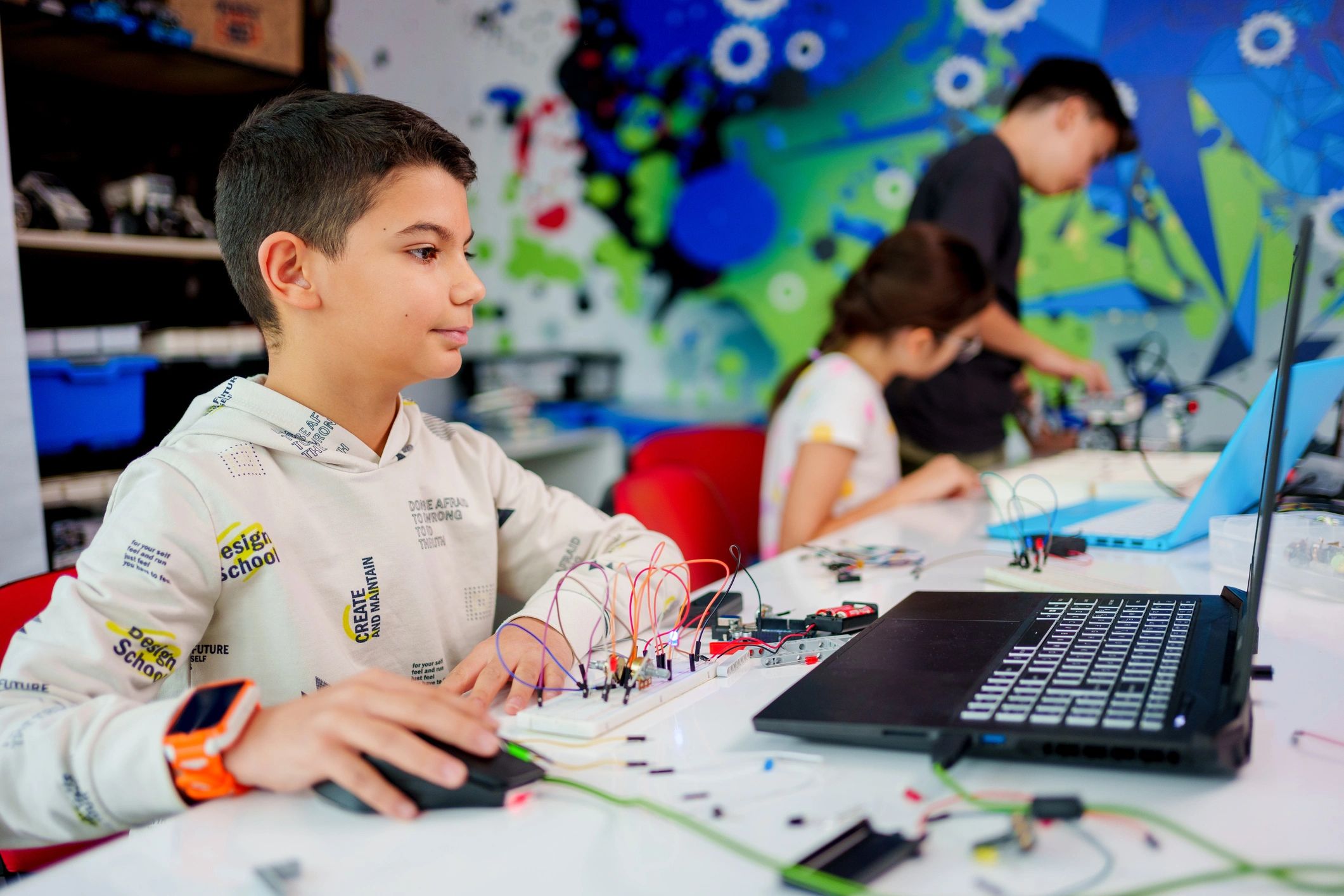 Students working on coding and robotics with laptops