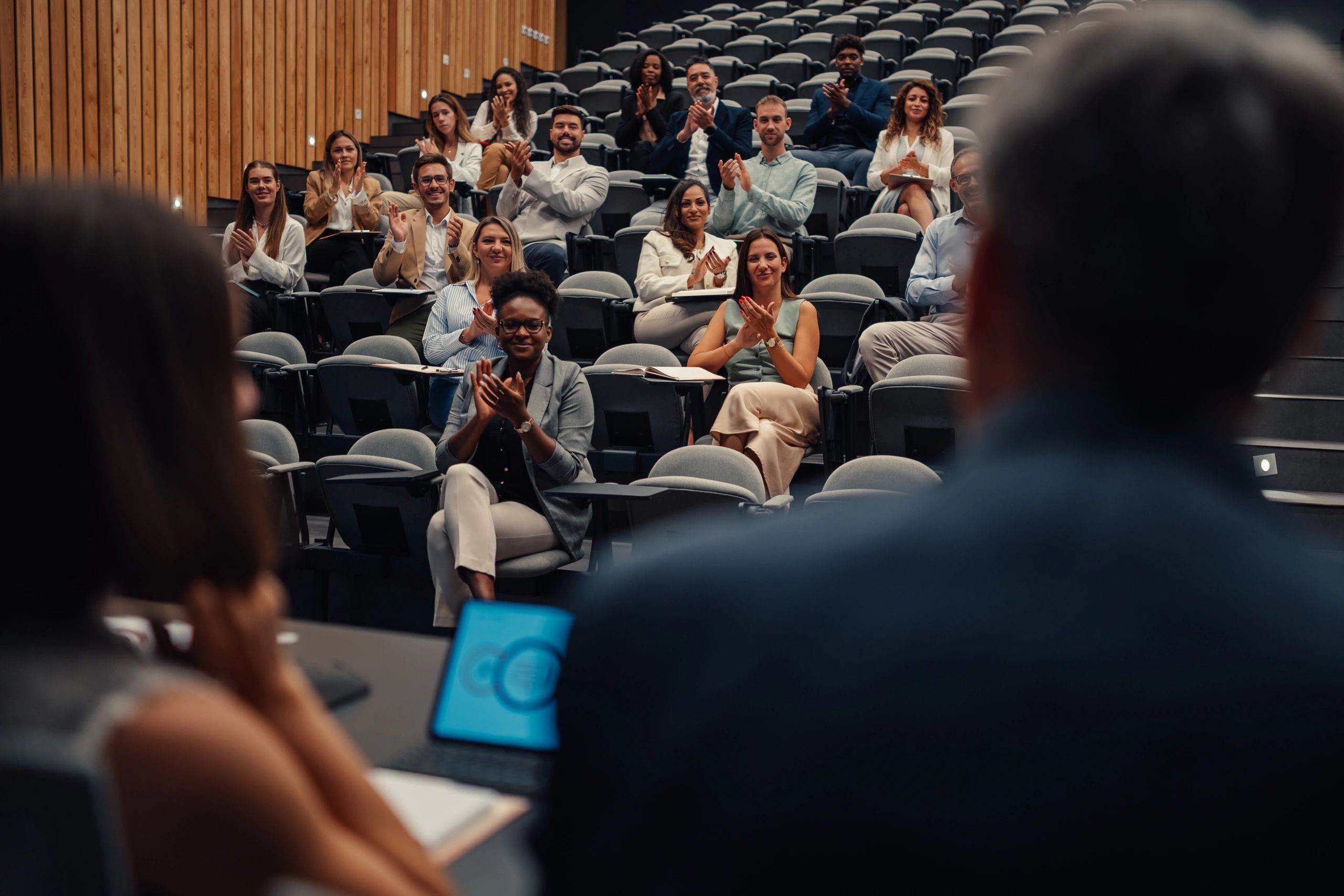 Community stakeholders at a meeting applauding a presentation